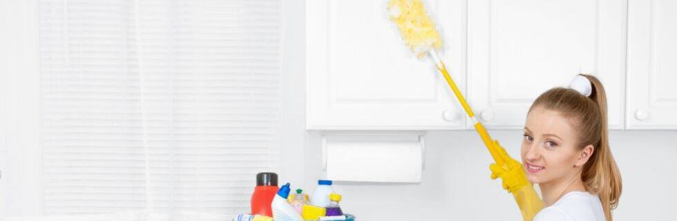 Woman dusting off the kitchen cabinets with a yellow duster